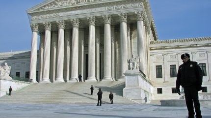 Supreme Court building with police officer standing on plaza