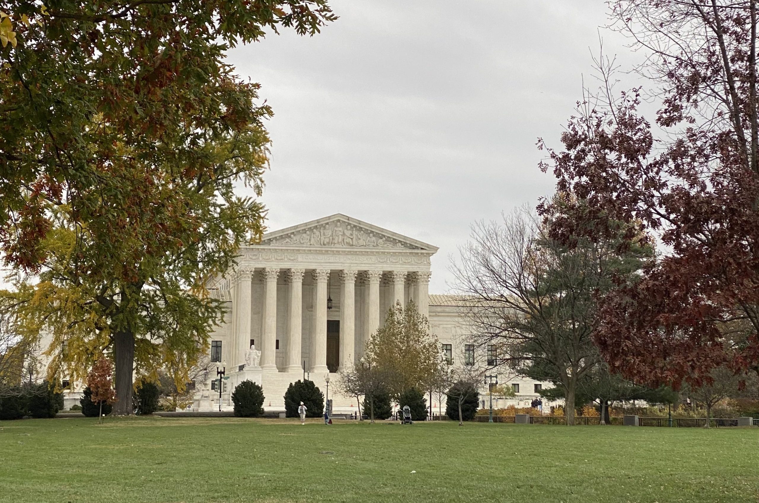 Supreme Court building seen from a distance surrounded by trees