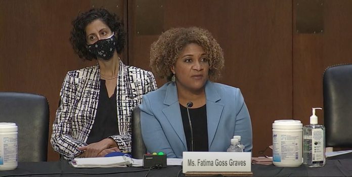 Fatima Graves speaking at senate hearing. Woman behind here in mask.