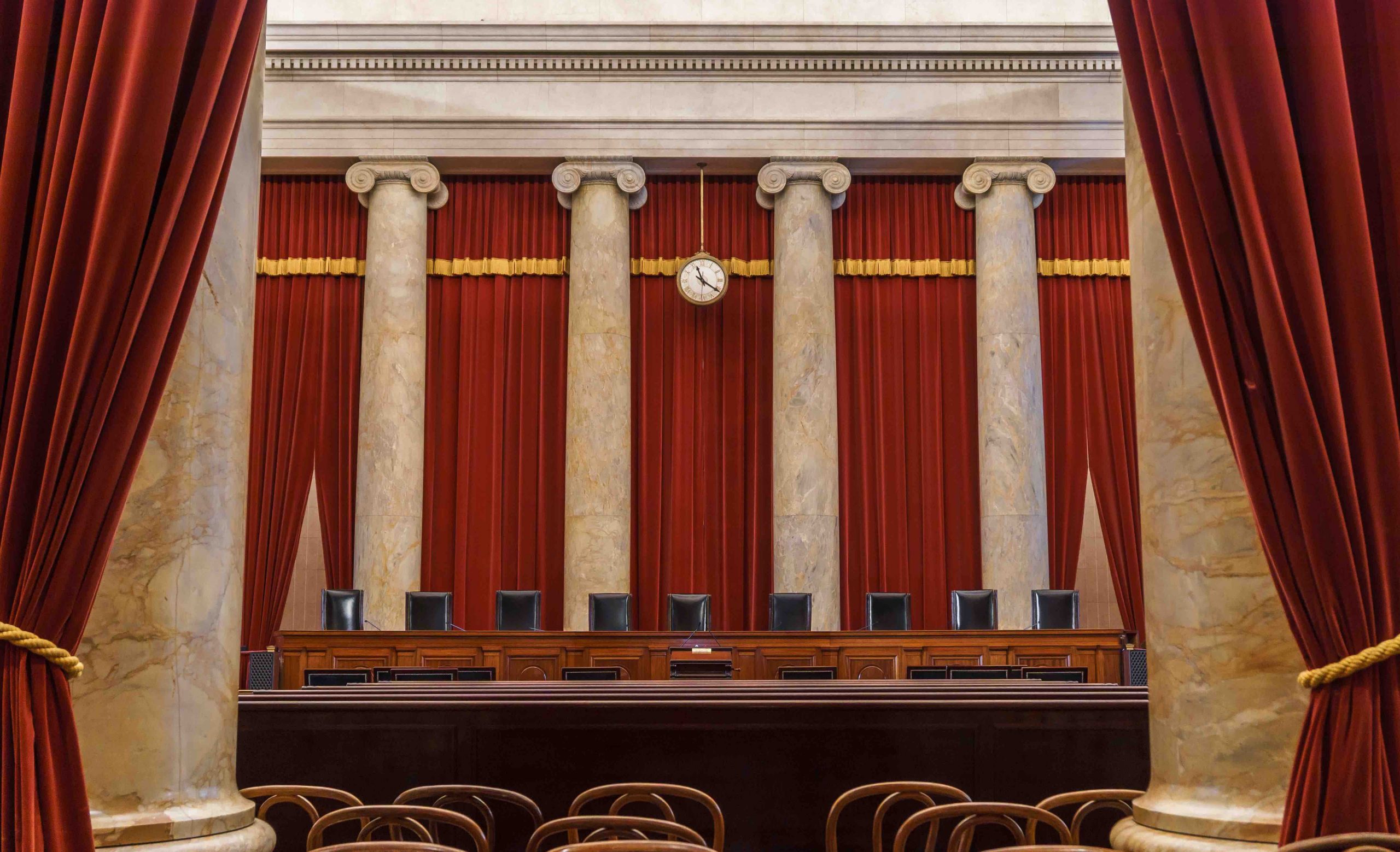 view of empty supreme court bench as seen from back of courtroom