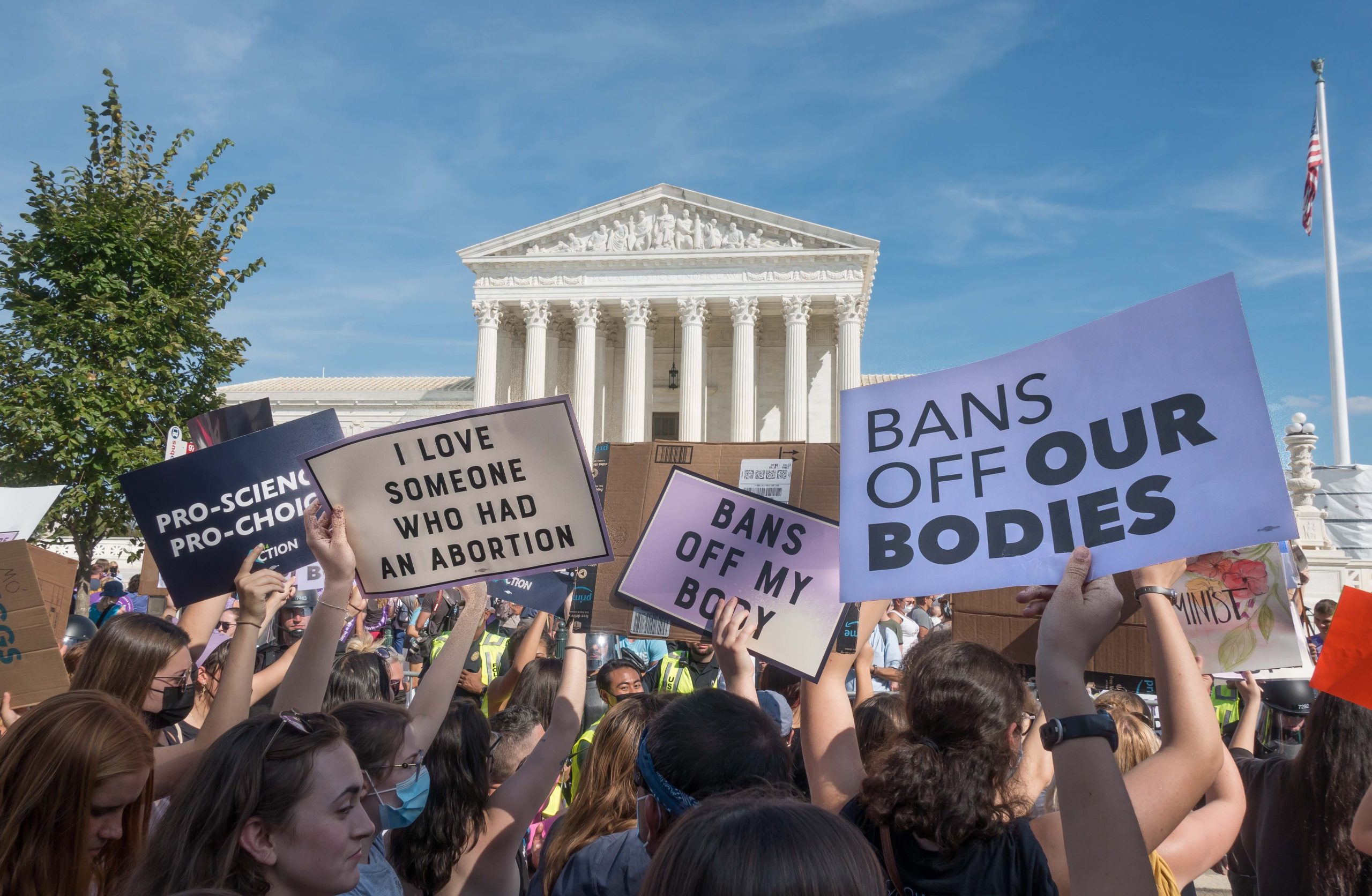 crowd of women in front of supreme court, holding signs supporting abortion rights