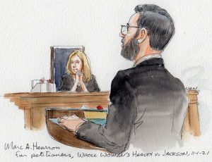 man with beard standing upright at lectern with amy coney barrett listening in background