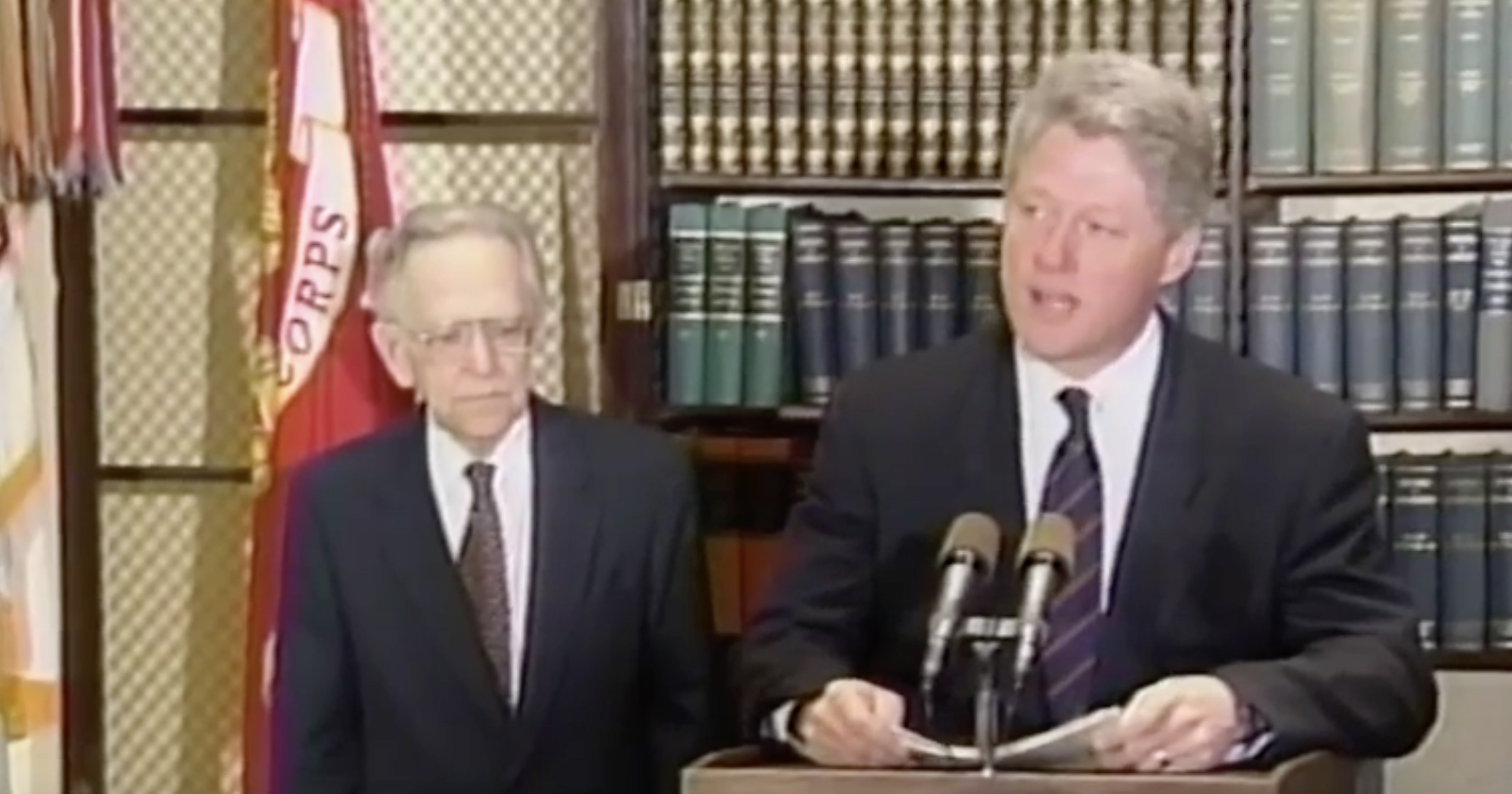 bill clinton speaking at lectern with harry blackmun standing beside him