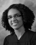 Woman in judicial robes smiling and wearing glasses