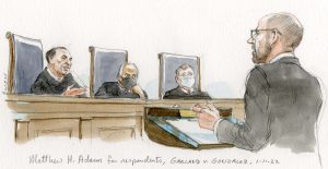 man in gray suit argues before three justices, two of whom sport masks