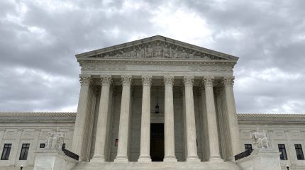 front view of supreme court with solitary person walking on plaza in front