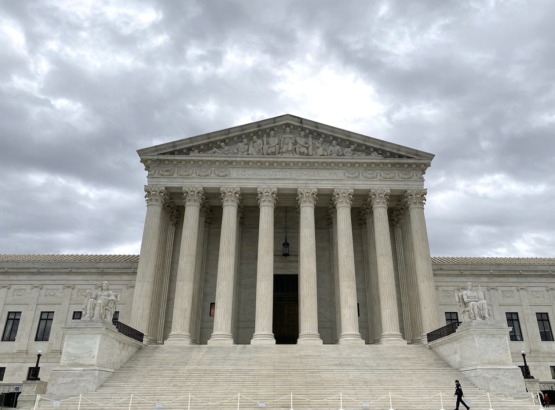 front view of supreme court with solitary person walking on plaza in front