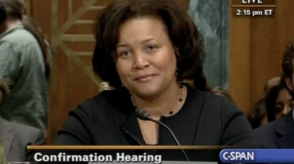 woman speaking at microphone in congressional hearing room