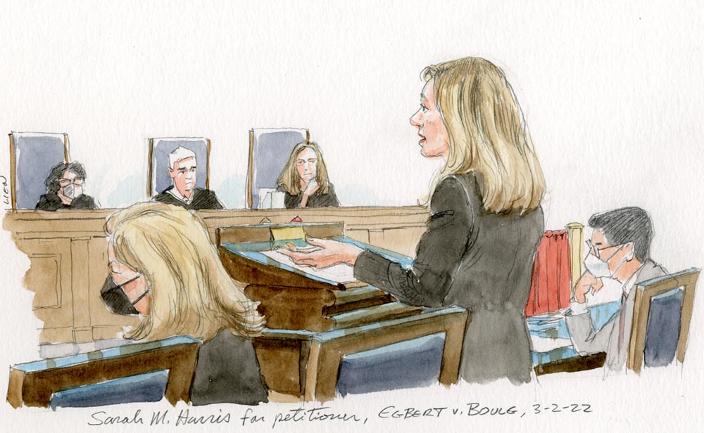 Woman speaking at lectern in front of three justices.