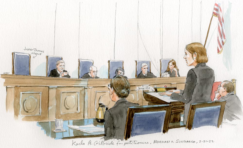 A woman arguing before the justices, using braille notes.