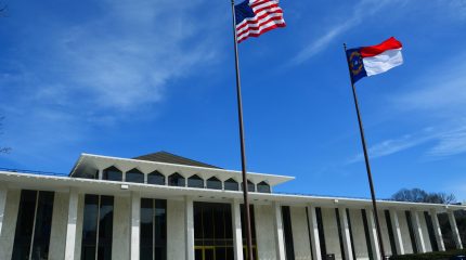 The North Carolina Legislative Building with the North Carolina and U.S. flags flying