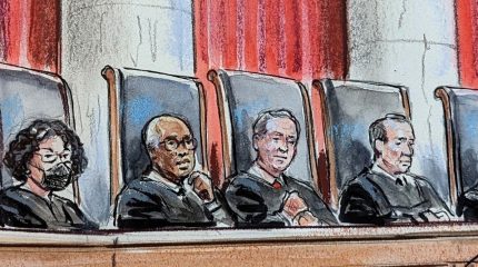 artist's rendition of nine justices in robes sitting behind judicial bench, looking out over an empty lectern. sonia sotomayor wears a mask. large curtains and an american flag hang in the background.