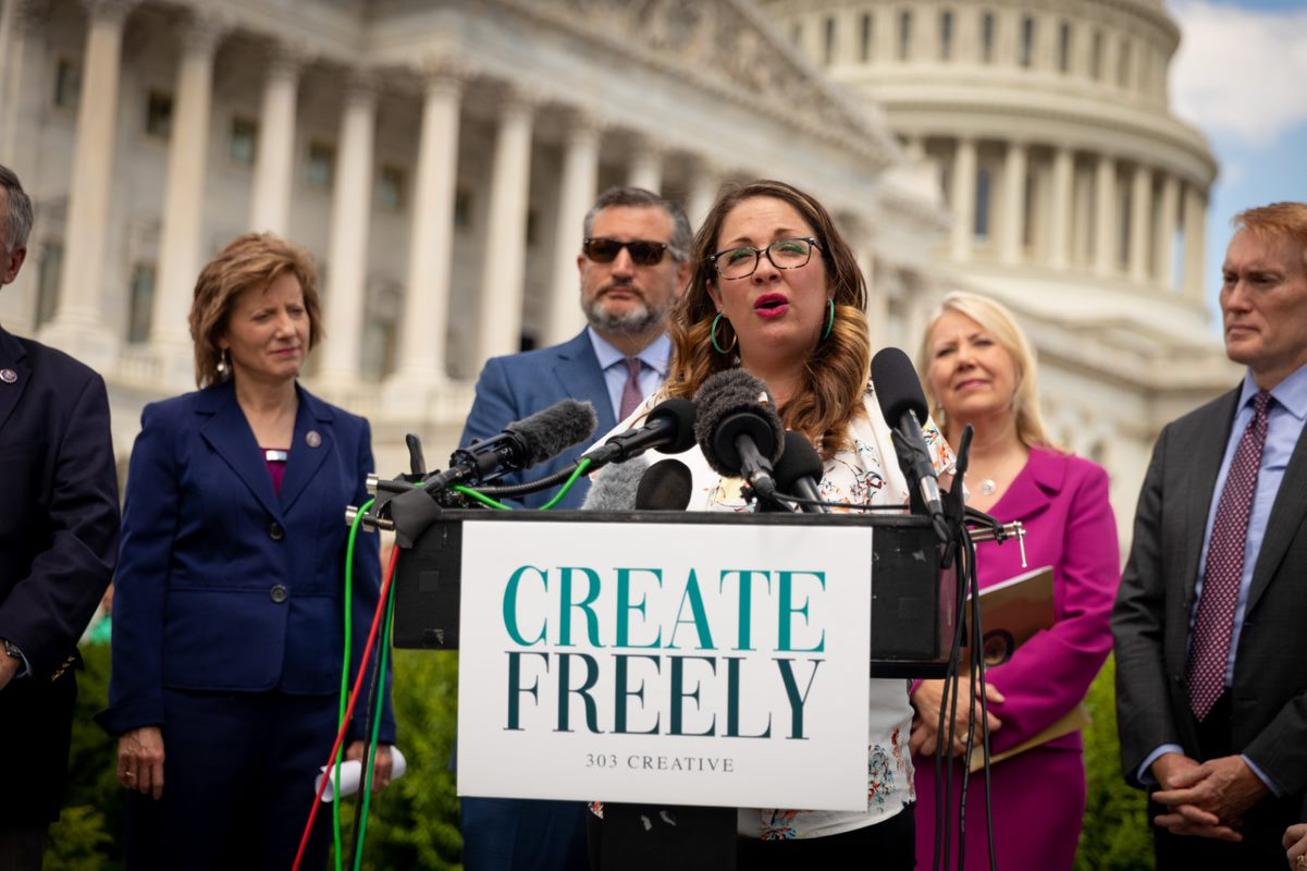 Woman speaking at podium in front of U.S. Capitol building