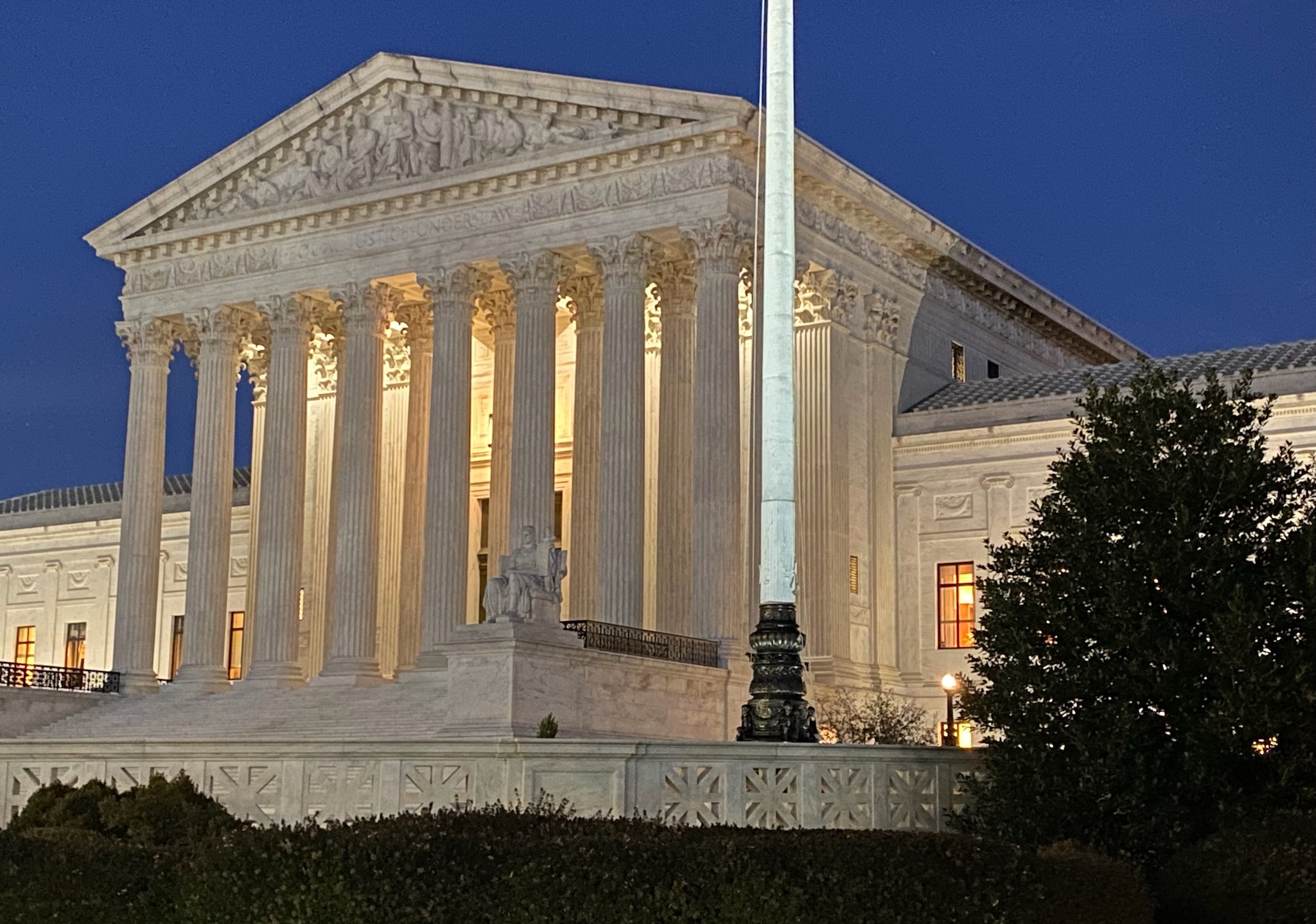 front of supreme court building illuminated against a dark sky