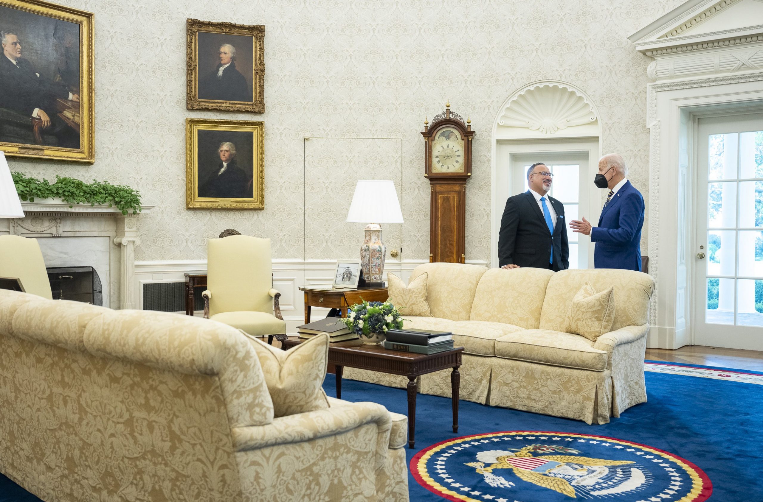 Two men, the president and education secretary, talk in the Oval Office.