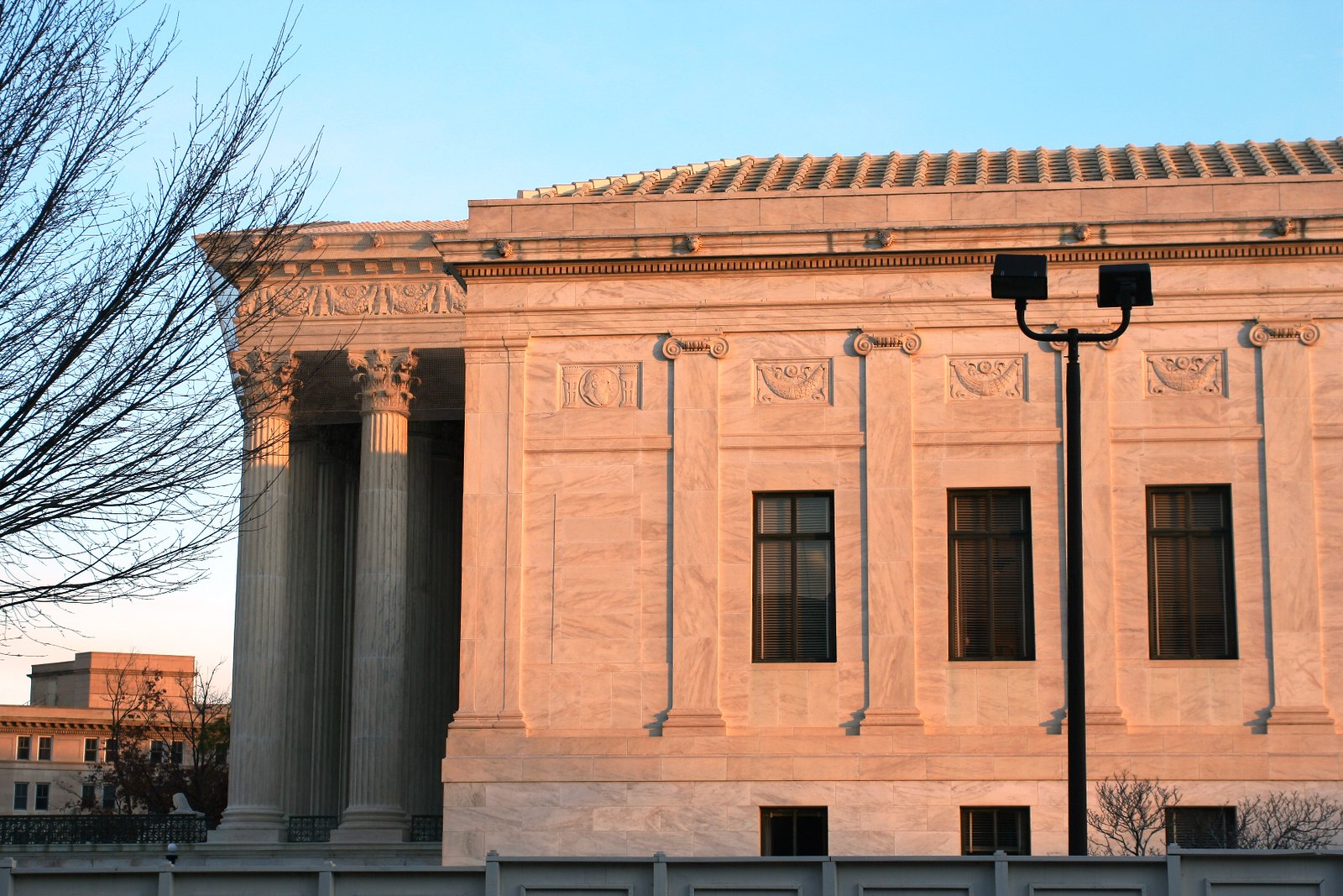 A side view of the Supreme Court building in pink sunlight.