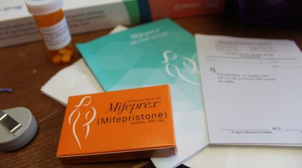A table with medical pamphlets and a box of the abortion pill mifepristone