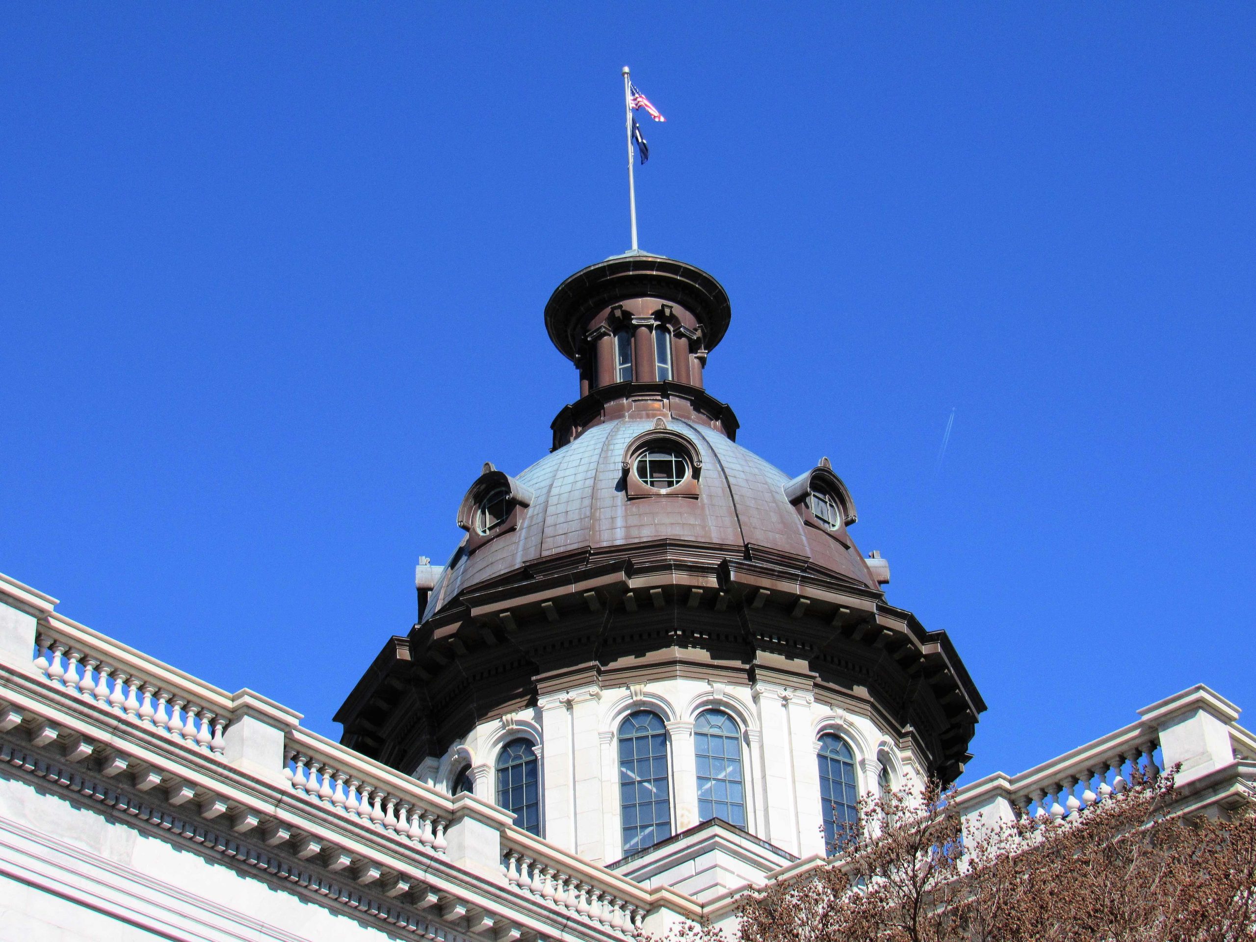 Dome of the South Carolina State House building with flags flying.