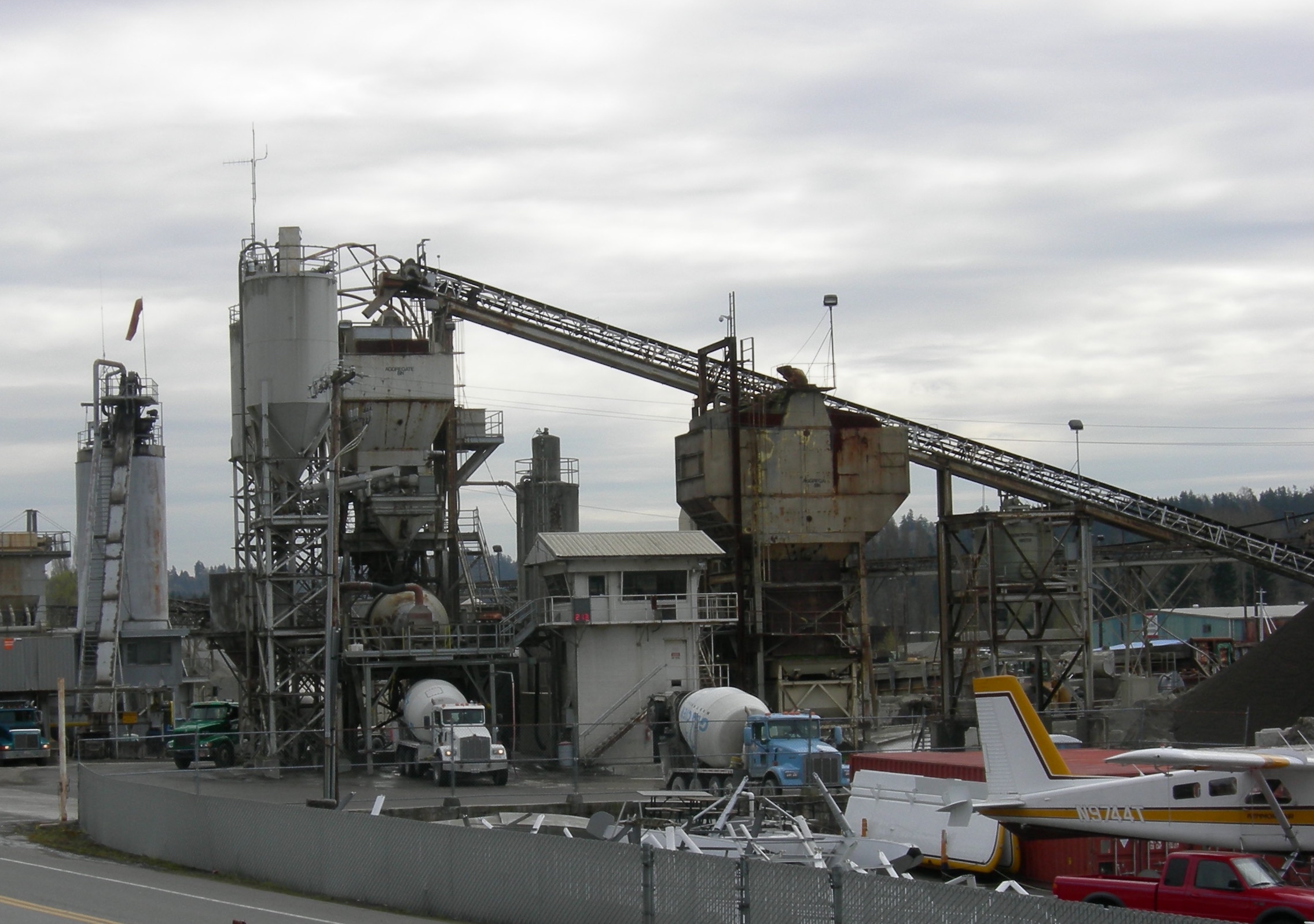 A cement plant with trucks being loaded with cement.