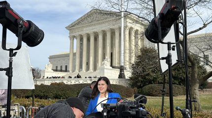 Woman stands before cameras outside the supreme court