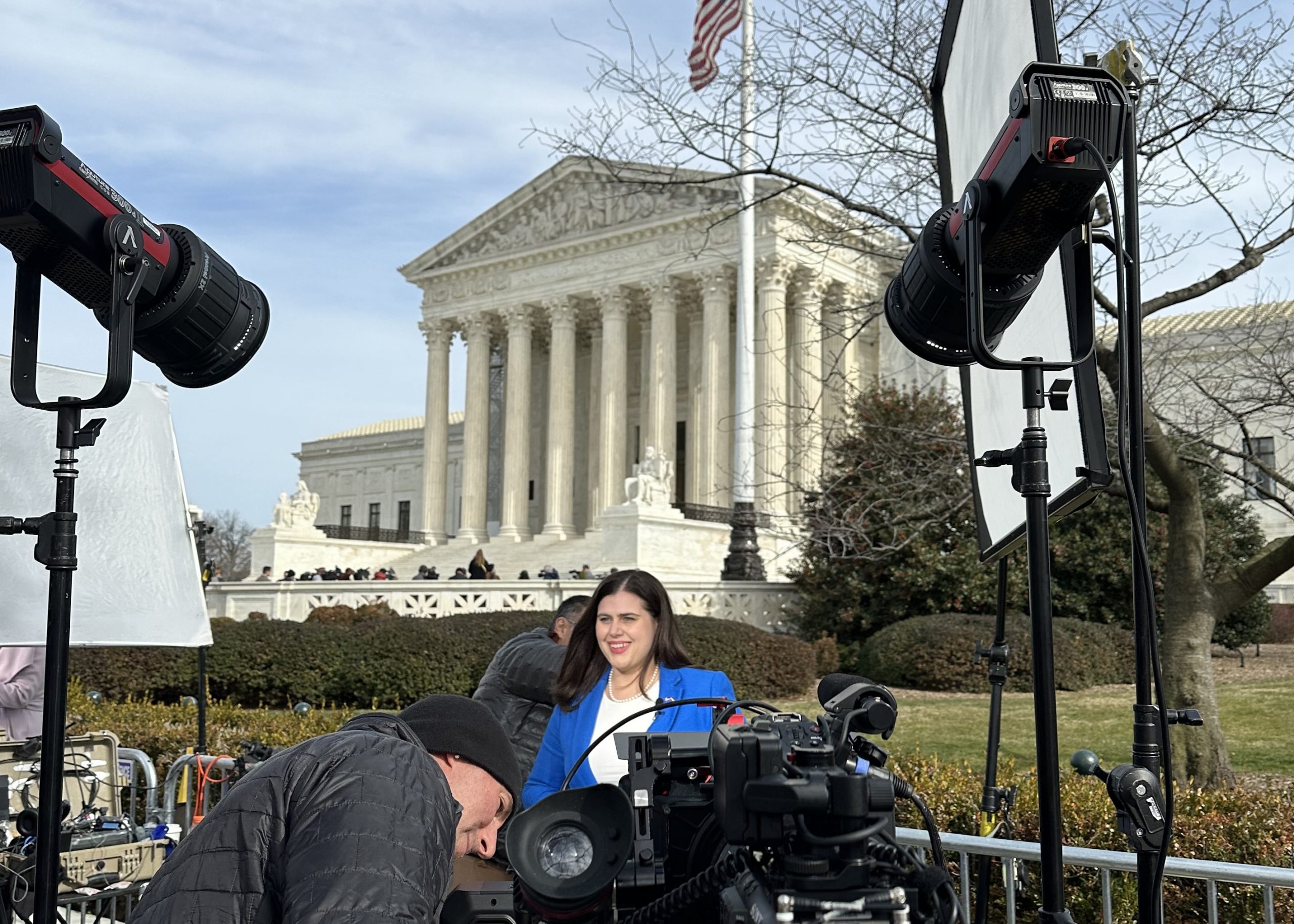 Woman stands before cameras outside the supreme court