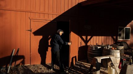 A man holds open a barn door
