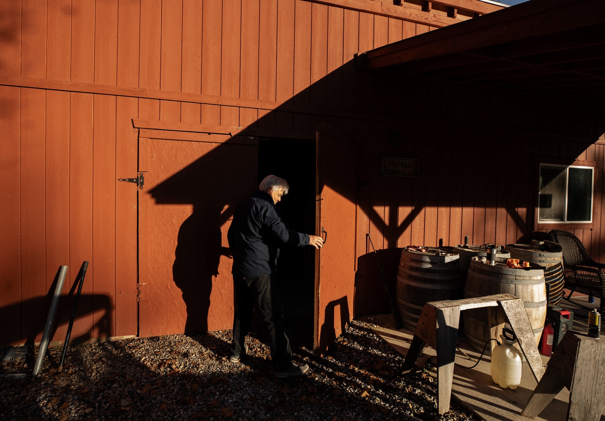 A man holds open a barn door